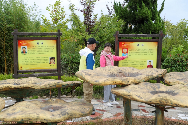 10月7日，在山东省青岛市即墨区温泉街道钱谷村，游客在交流优秀村民的事迹。